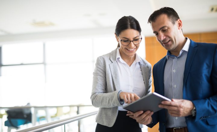Man and woman at work looking at a tablet